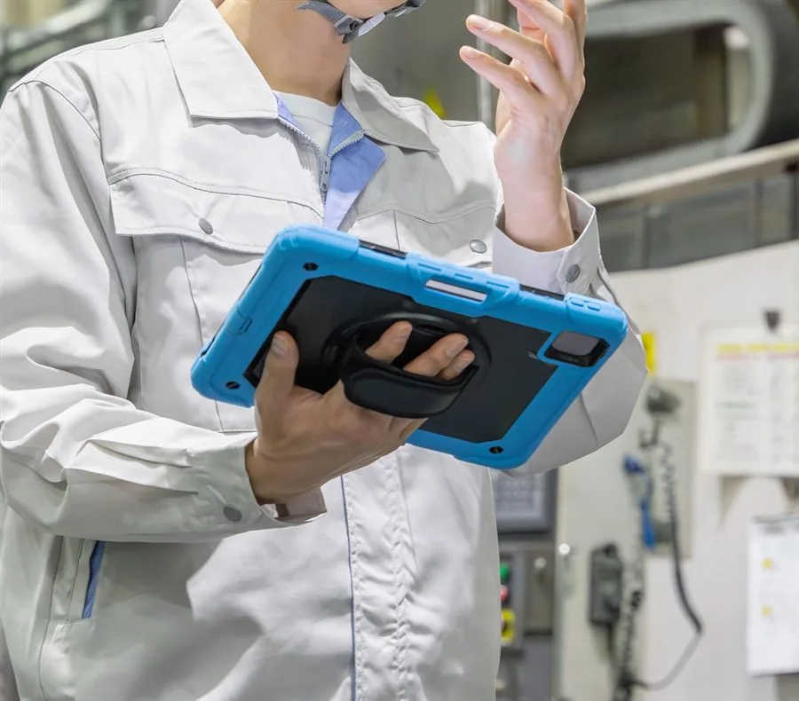 現場でタブレットを使い、動画マニュアルで作業手順を確認する様子